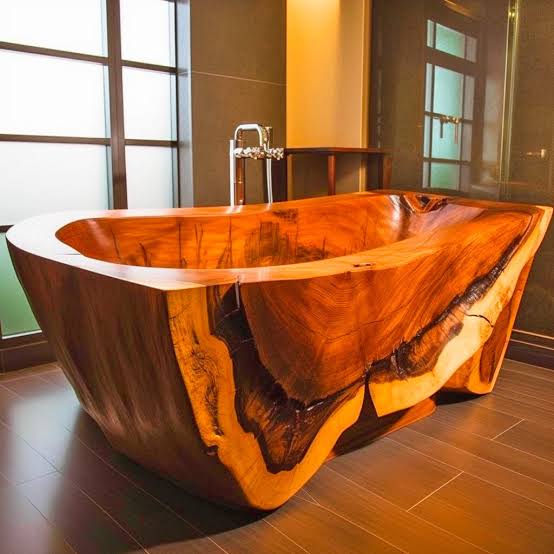 Handmade solid wood bathtub with live edge design and natural grain pattern, placed in a modern bathroom setting.